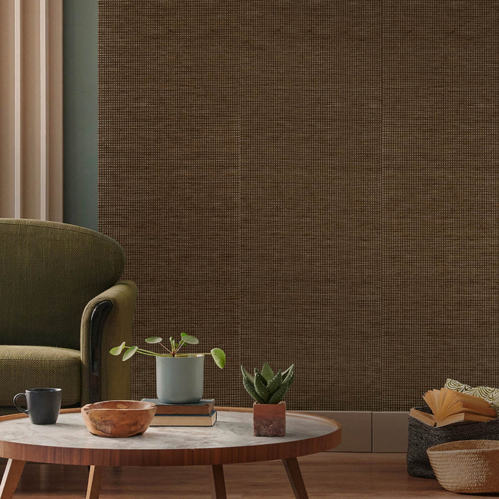 Living room with a textured brown wall, green armchair, wooden coffee table, and decorative items.