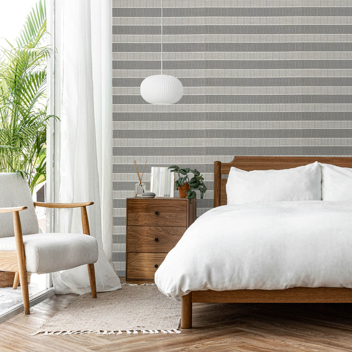 GoDear Modern bedroom with striped wallpaper, wooden bed, and armchair.