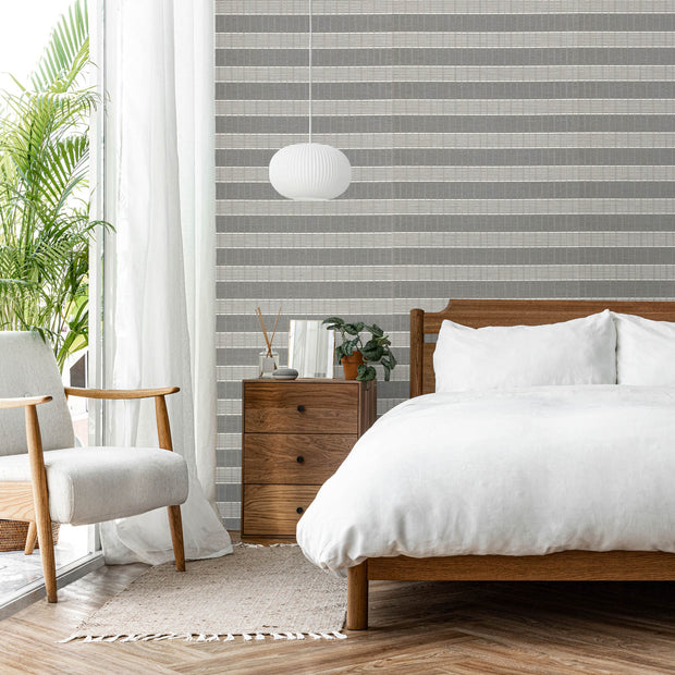 GoDear Modern bedroom with striped wallpaper, wooden bed, and armchair.