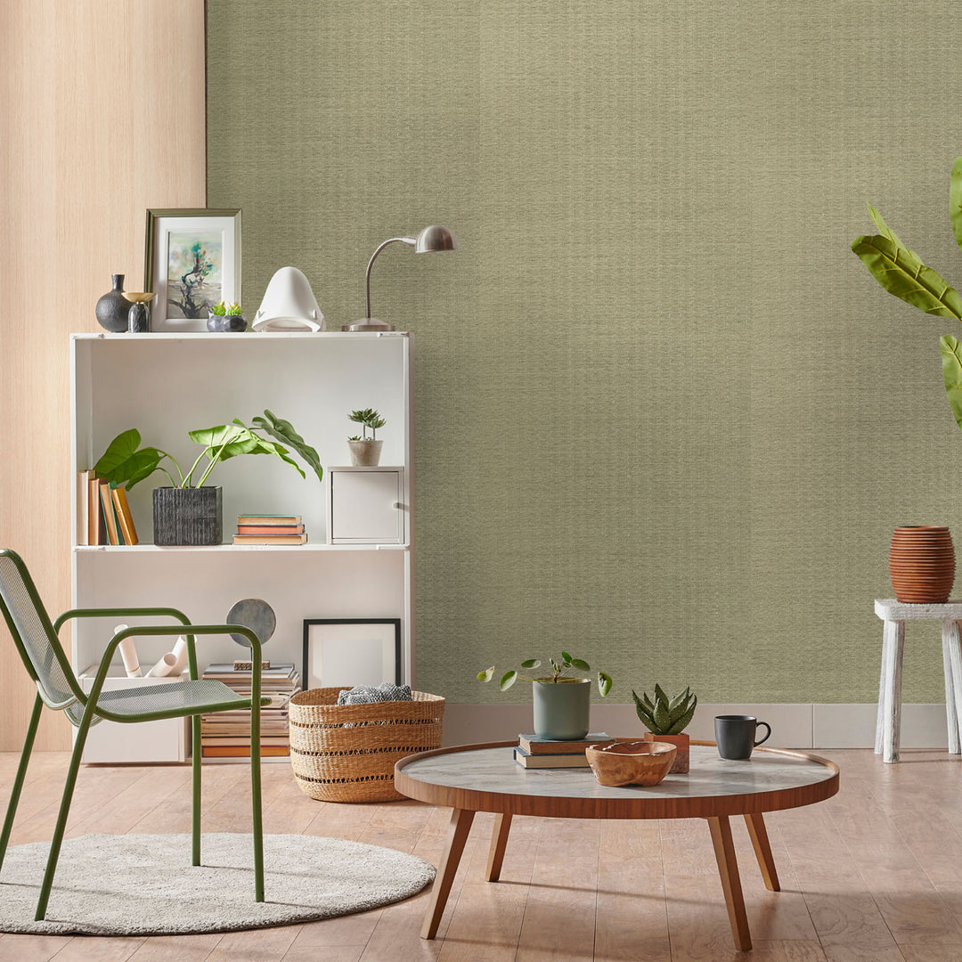 Living room with green textured wallpaper, wooden coffee table, and decorative items.