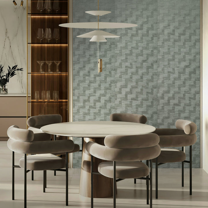 Modern dining room with a round table and chairs against a textured wall.