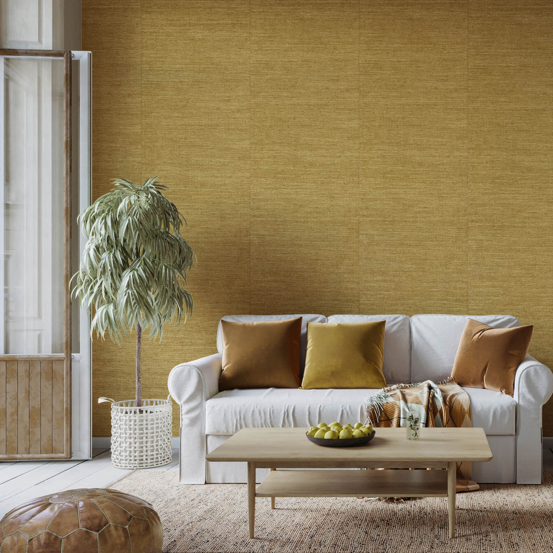 Living room with a white sofa, wooden coffee table, and decorative pillows against a mustard yellow wall.