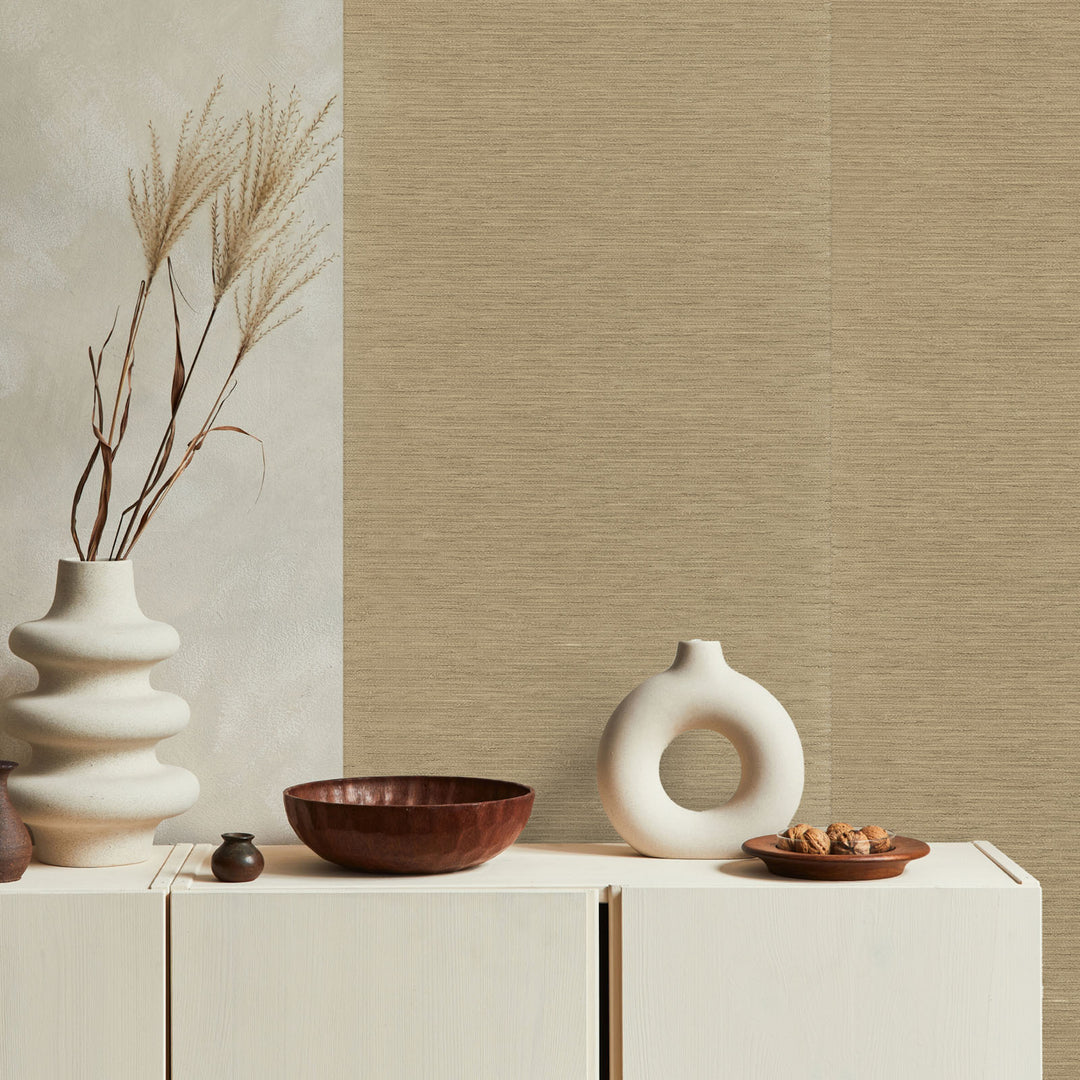 Decorative setting with vases and bowls on a cabinet against a textured wall.