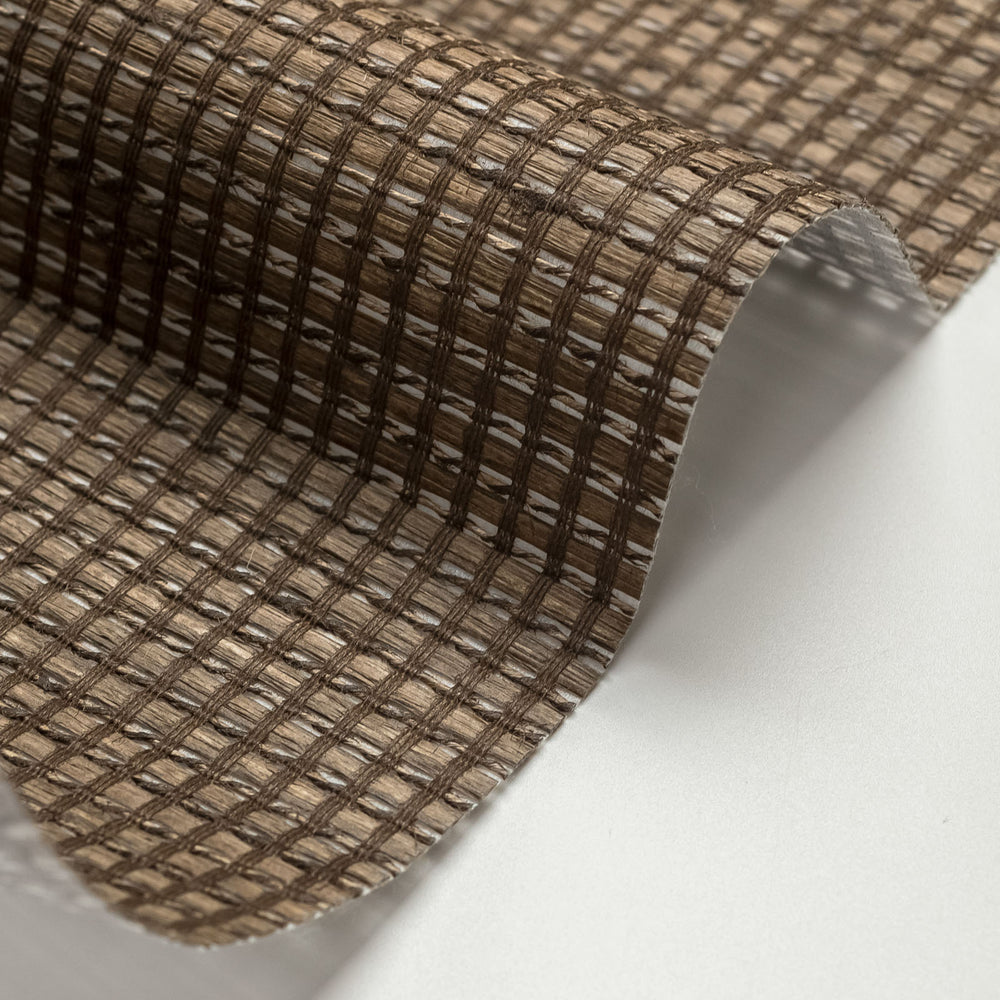 Close-up of a roll of brown woven material on a white background