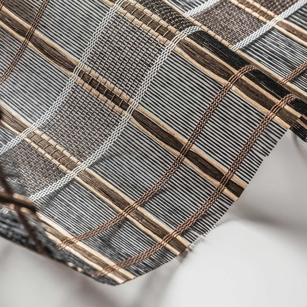 Close-up of woven fabric with brown and gray stripes on a white background