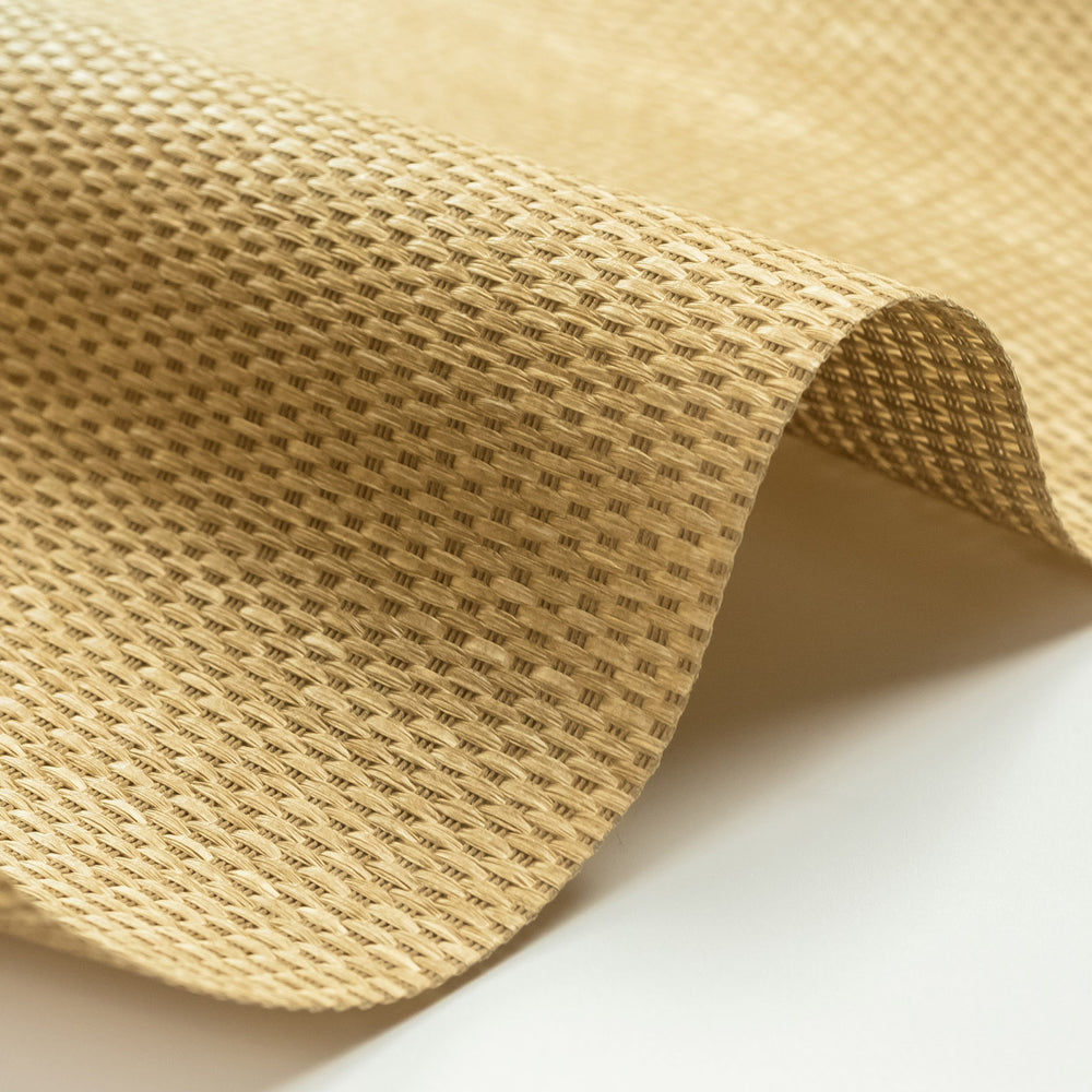 Close-up of beige textured fabric with a roll on a light background