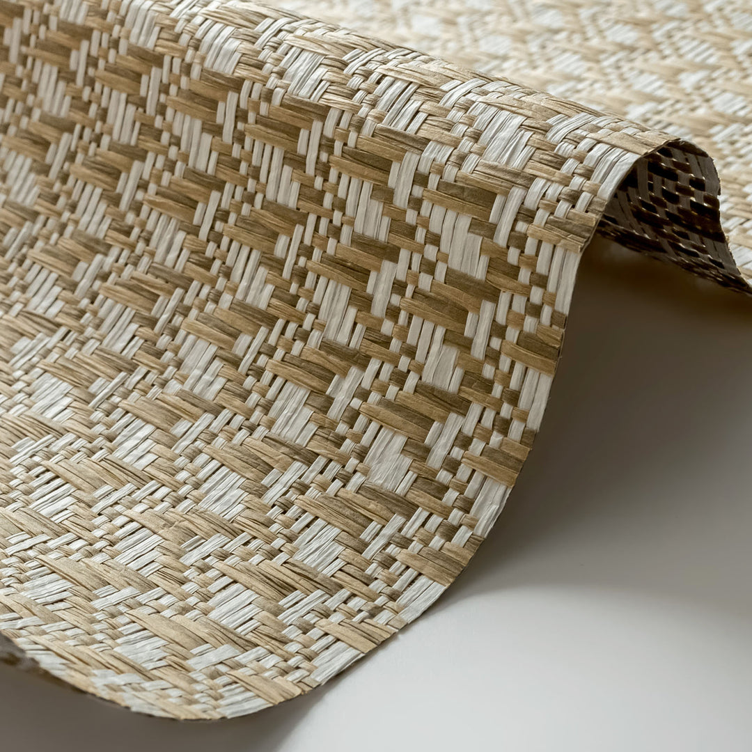 Close-up of a woven mat with a geometric pattern on a neutral background