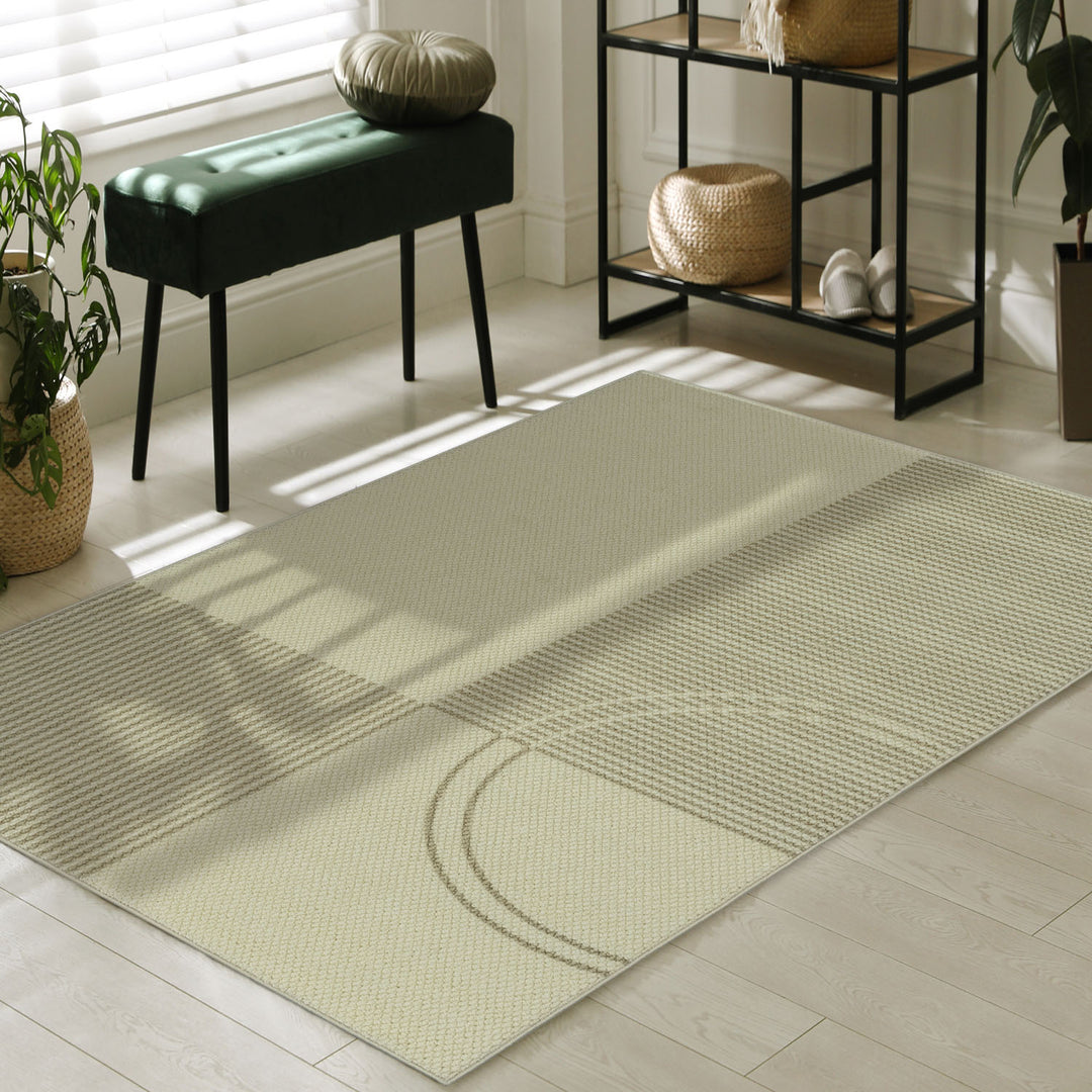 Beige rug on a wooden floor with a green bench and decorative items in the background.
