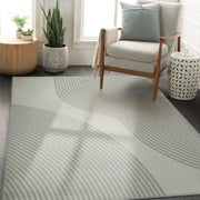 Living room with a patterned rug, armchair, and decorative items.