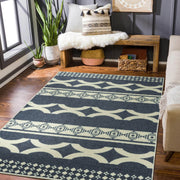 Patterned rug on a wooden floor with a bench and decorative items in the background