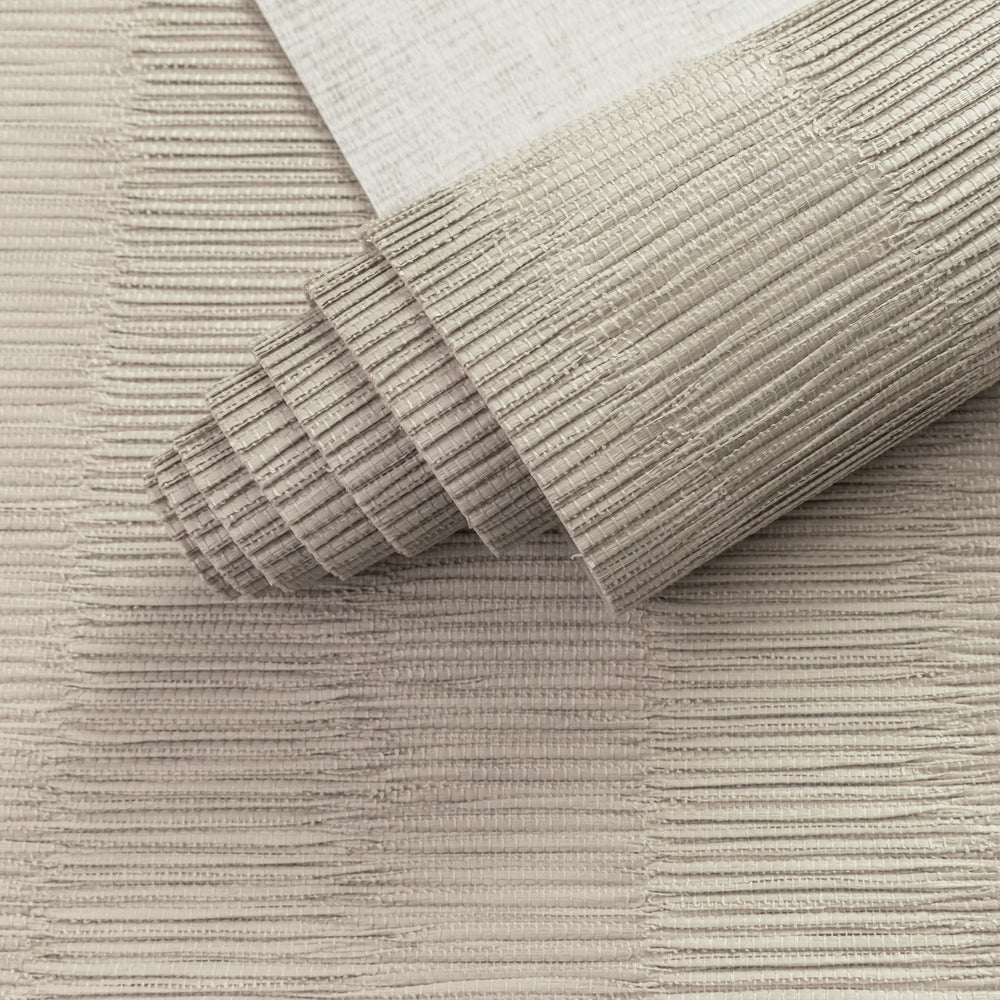 Close-up of a textured beige rug with a roll of the same material.
