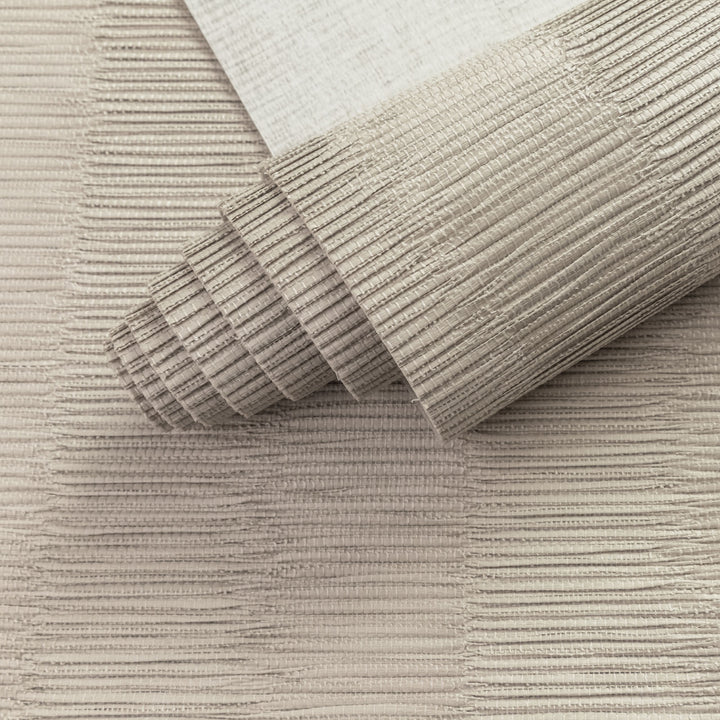 Close-up of a textured beige rug with a roll of the same material.