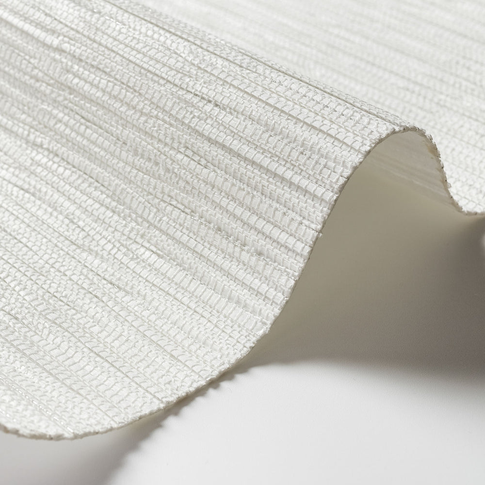 Close-up of a textured white fabric with a soft shadow on a light background