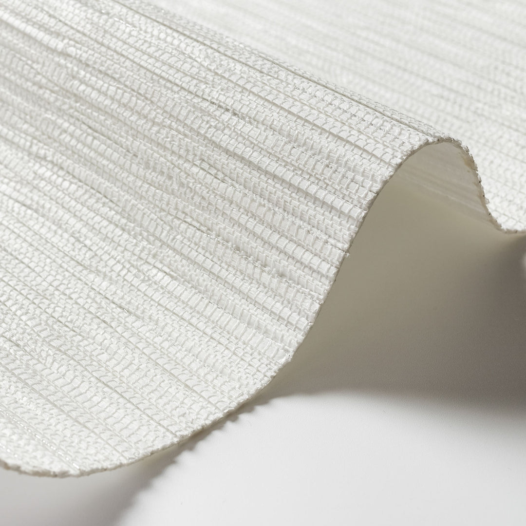Close-up of a textured white fabric with a soft shadow on a light background