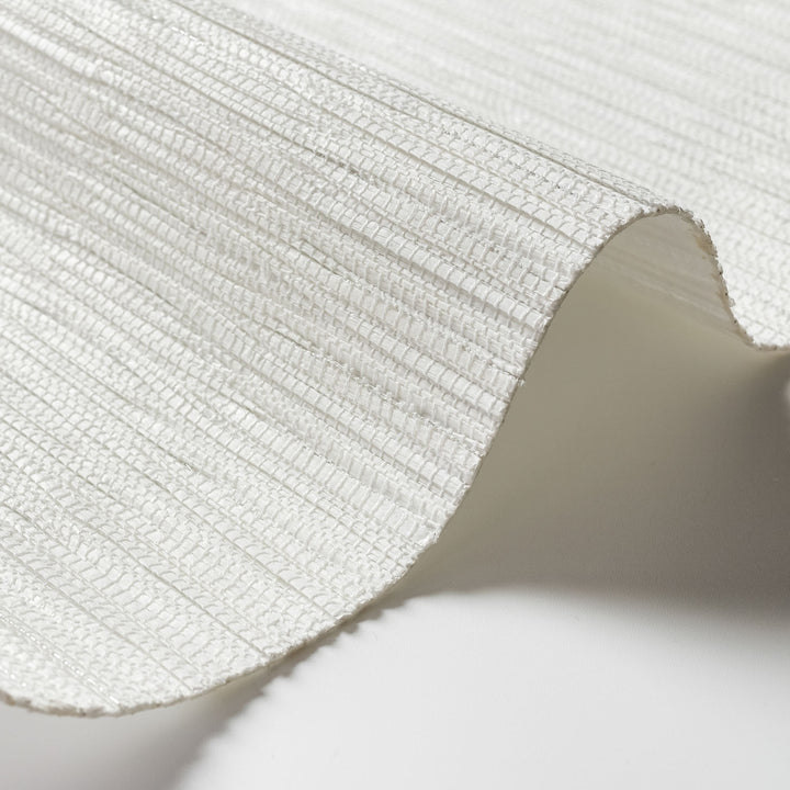 Close-up of a textured white fabric with a soft shadow on a light background