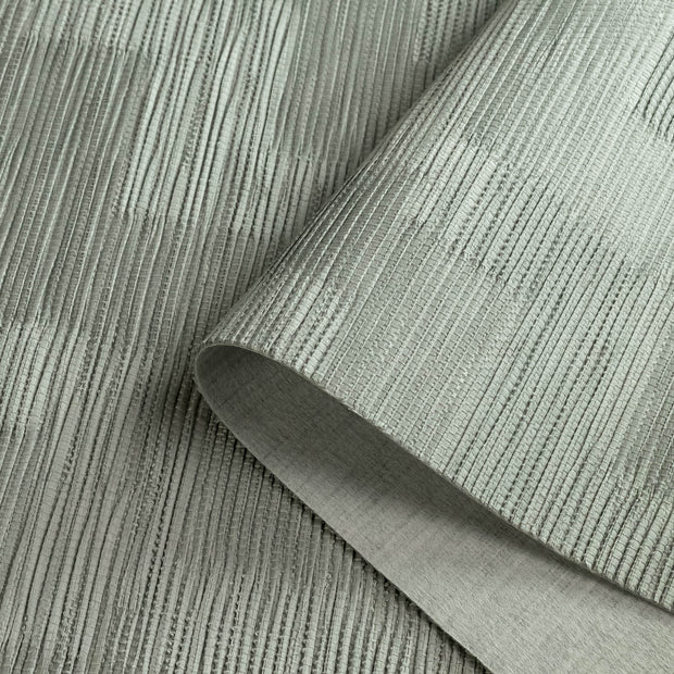 Textured green fabric with a roll of fabric on a matching background