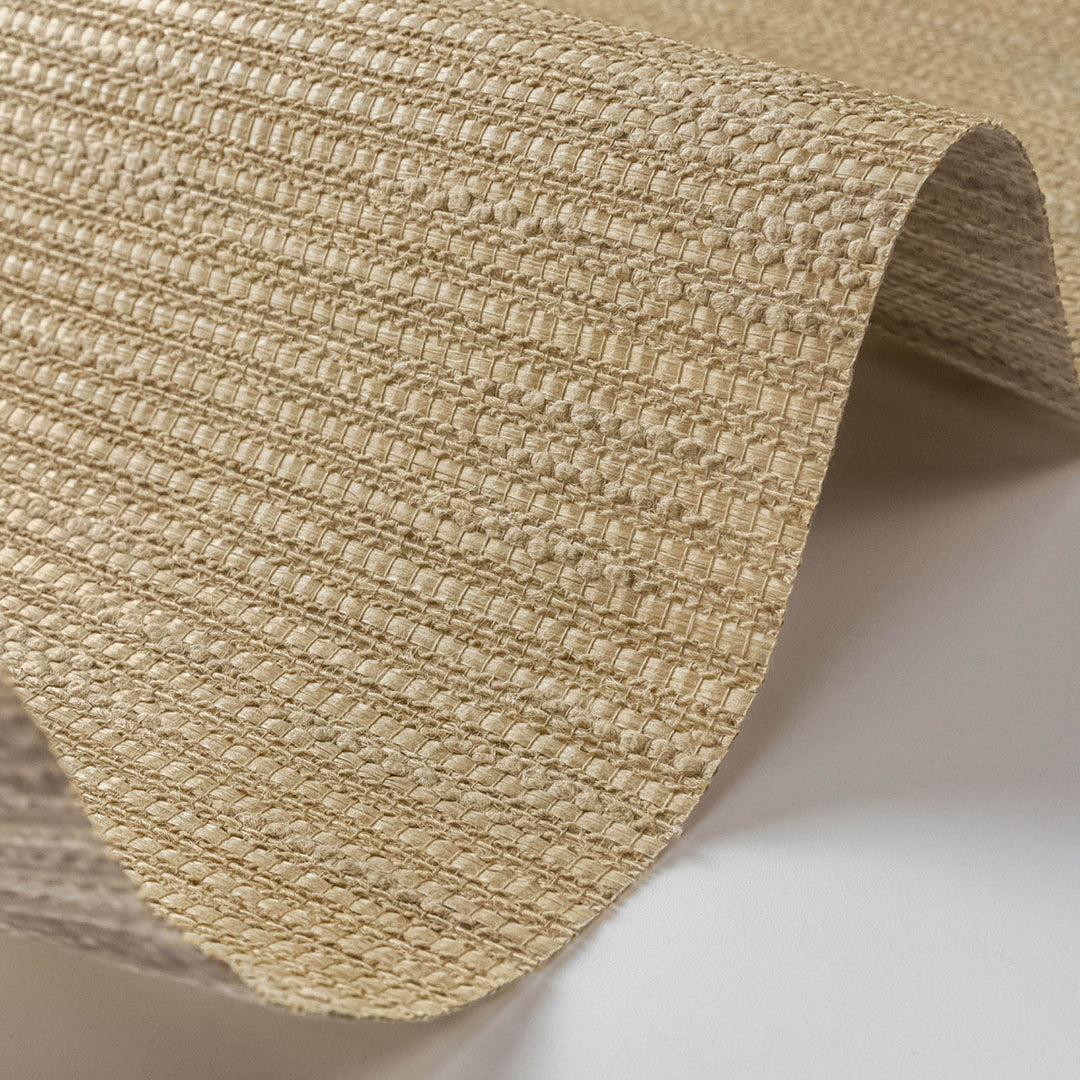 Close-up of a textured beige fabric roll on a white background