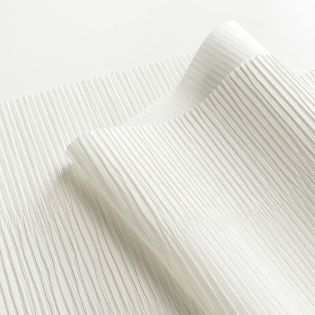 Close-up of white fabric with a subtle pattern on a white background