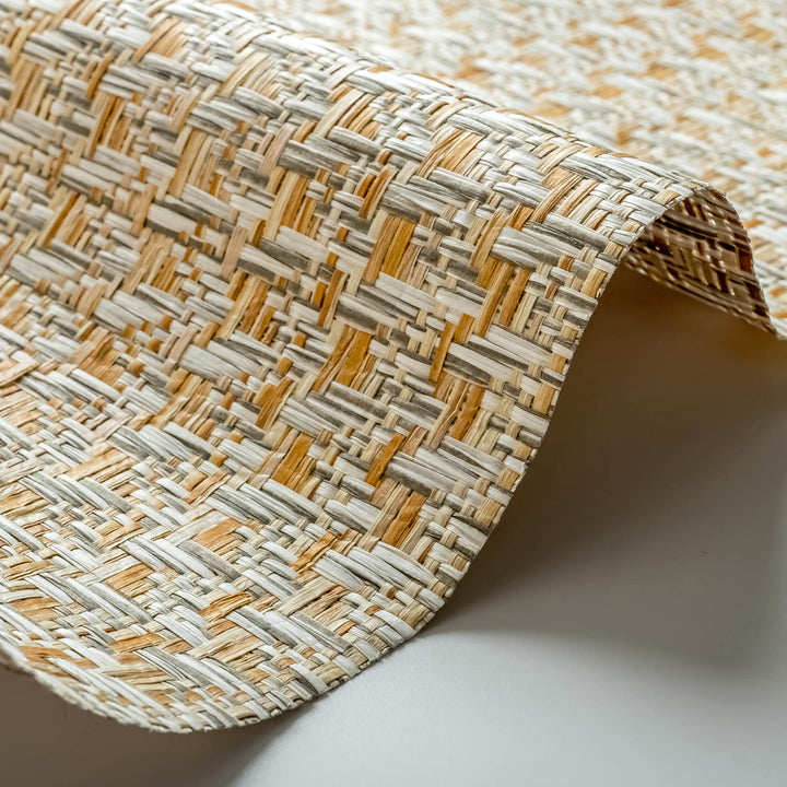 Close-up view of woven wallpaper fabric showing beige, tan, and gray interlaced fibers with natural textured pattern.
