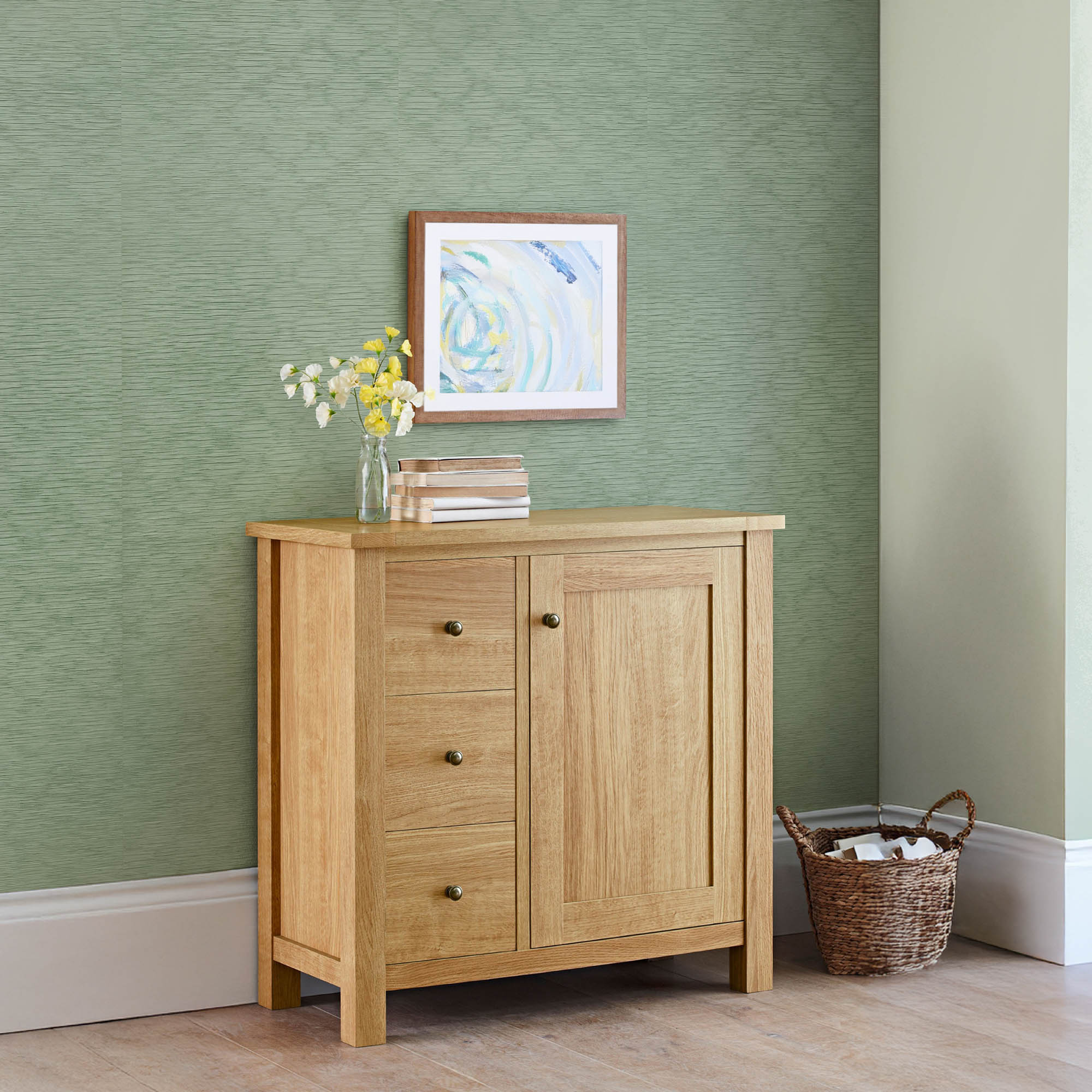 Light green textured wall backdrop with wooden cabinet, minimalist artwork, and woven basket in a cozy modern interior.