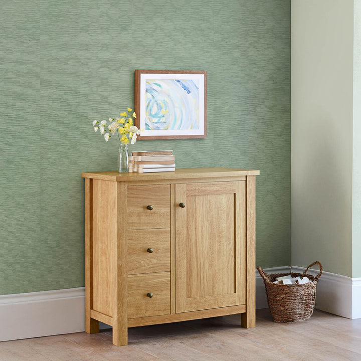 Light green textured wall backdrop with wooden cabinet, minimalist artwork, and woven basket in a cozy modern interior.