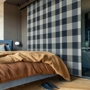 GoDear Design Bedroom with plaid wall, brown bedspread, and blue slippers on wooden floor.
