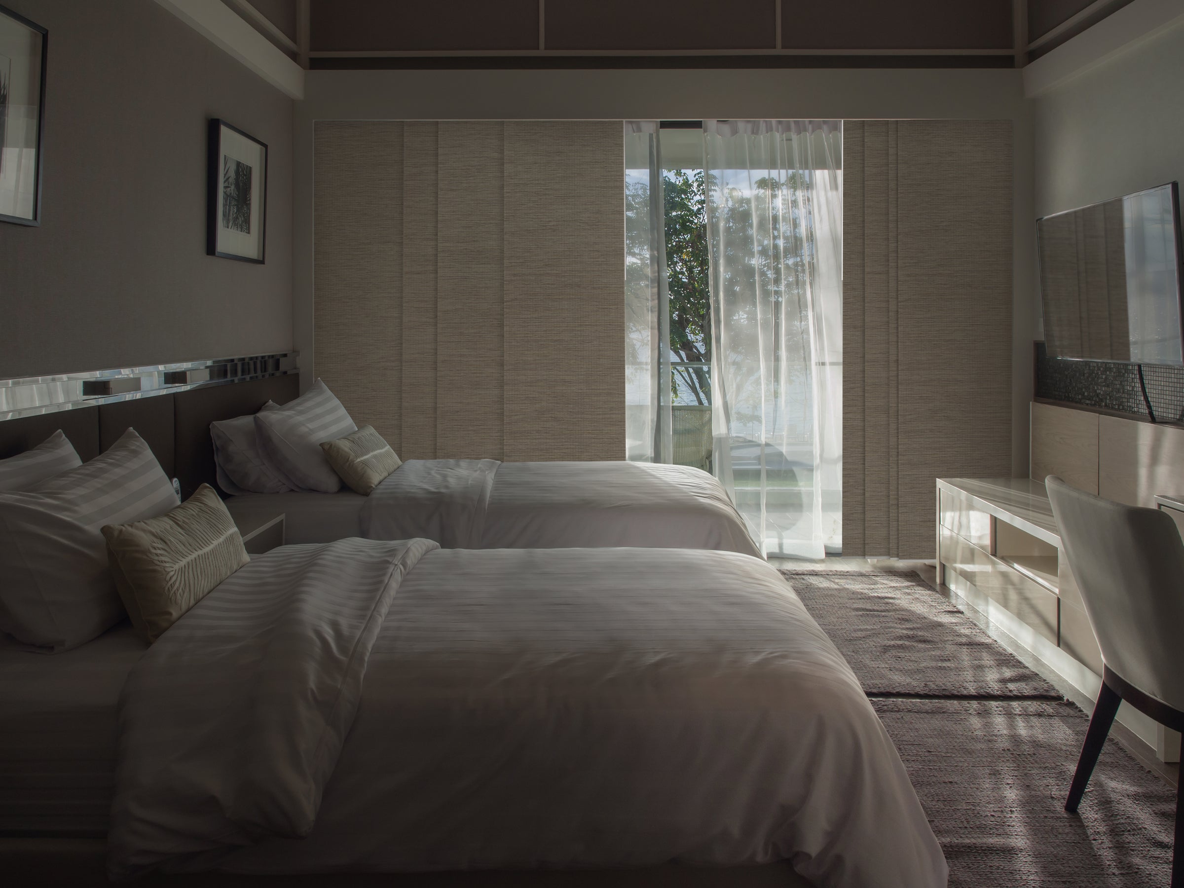 GoDear Design_Modern bedroom with two beds and a large window.
