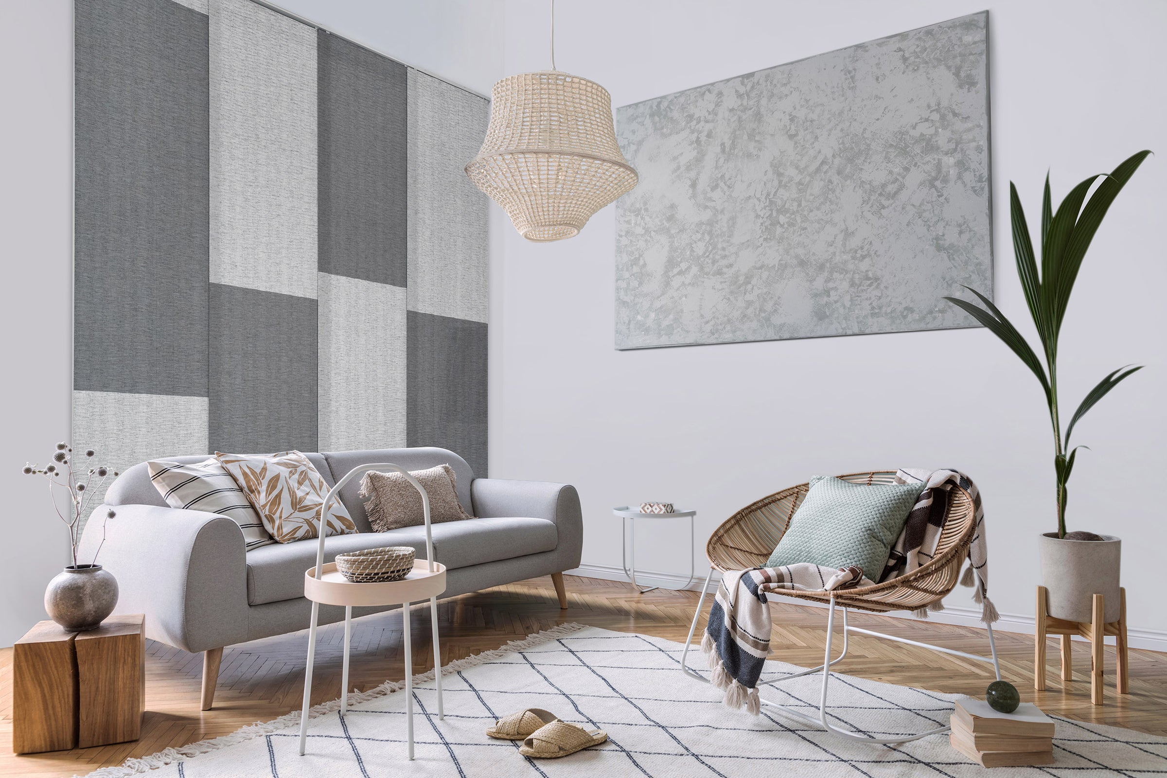 GoDear Design_Modern living room with gray sofa, wicker chair, and geometric wall art.