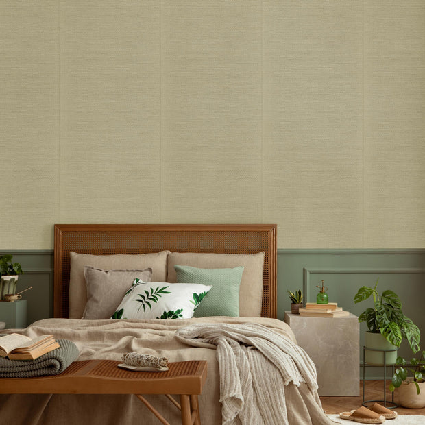 Cozy bedroom with beige textured wall, wooden rattan headboard, layered neutral bedding, and green accent decor.