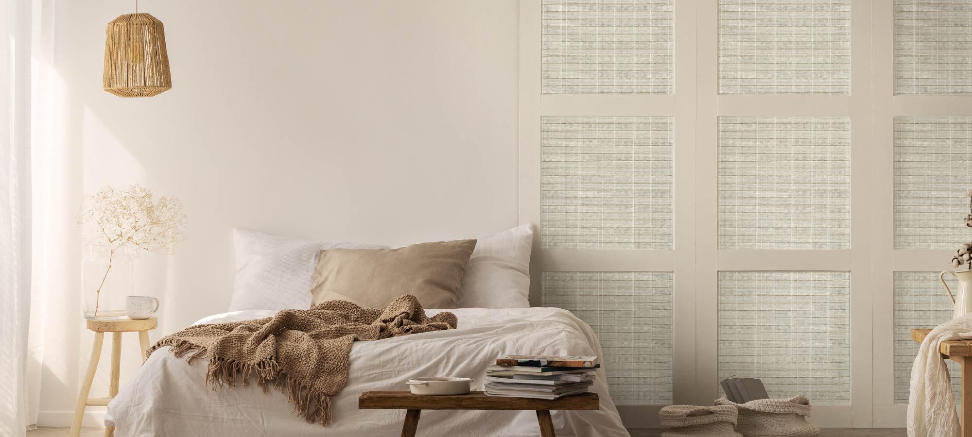 Minimalist cozy bedroom with natural woven pendant light, soft neutral bedding, wooden furniture, and textured sliding panels creating a warm relaxing atmosphere.