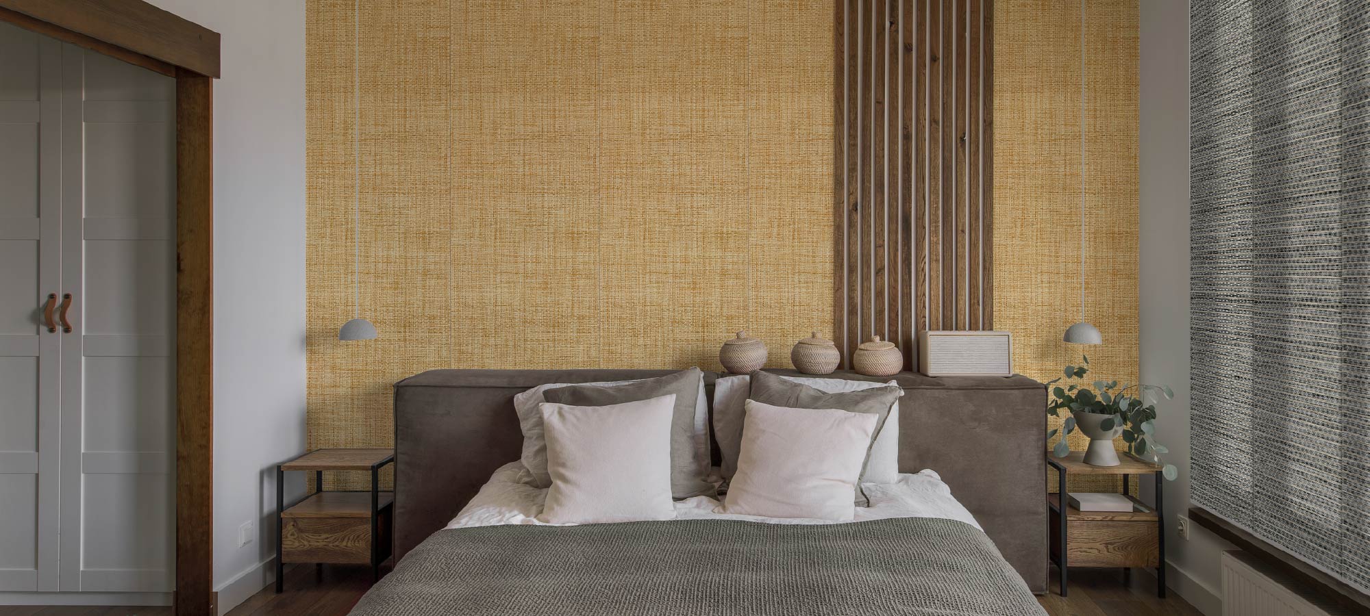 Contemporary bedroom interior with warm woven textured wall, upholstered headboard, neutral bedding, and wooden side tables with minimalist decor.