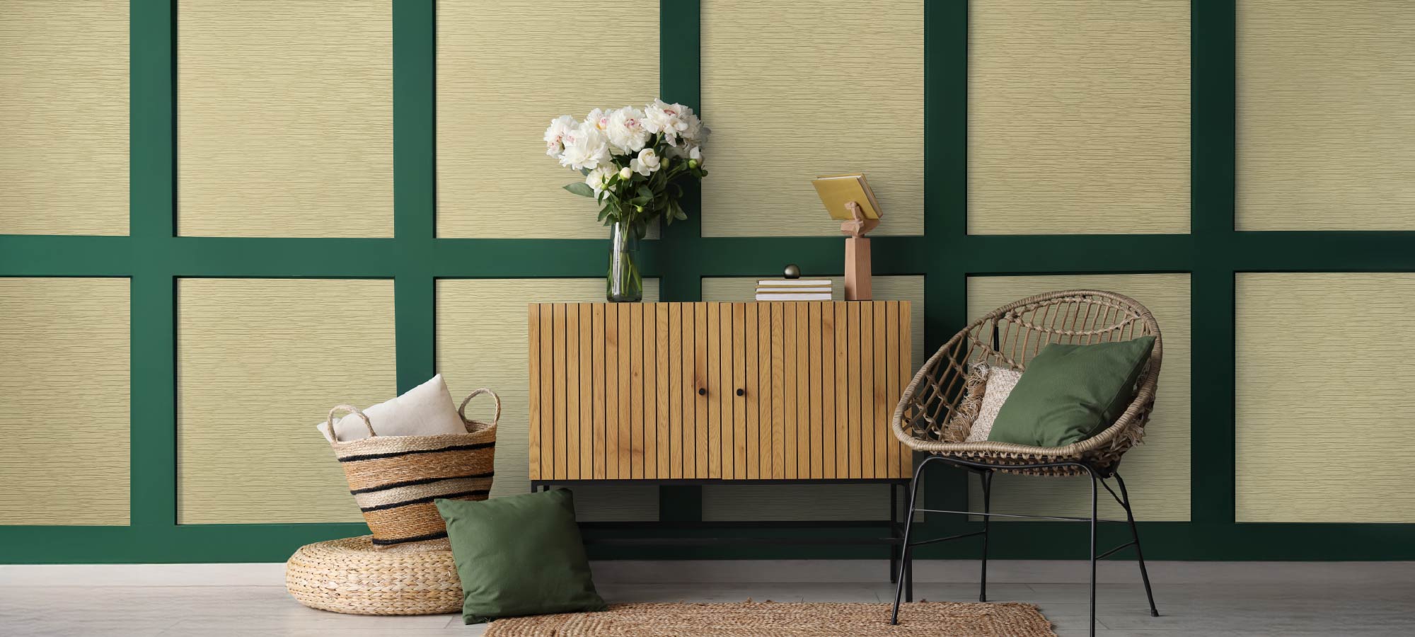 Cozy modern interior with green paneled accent wall, rattan chair with cushion, wooden sideboard, and woven baskets styled with natural home décor.