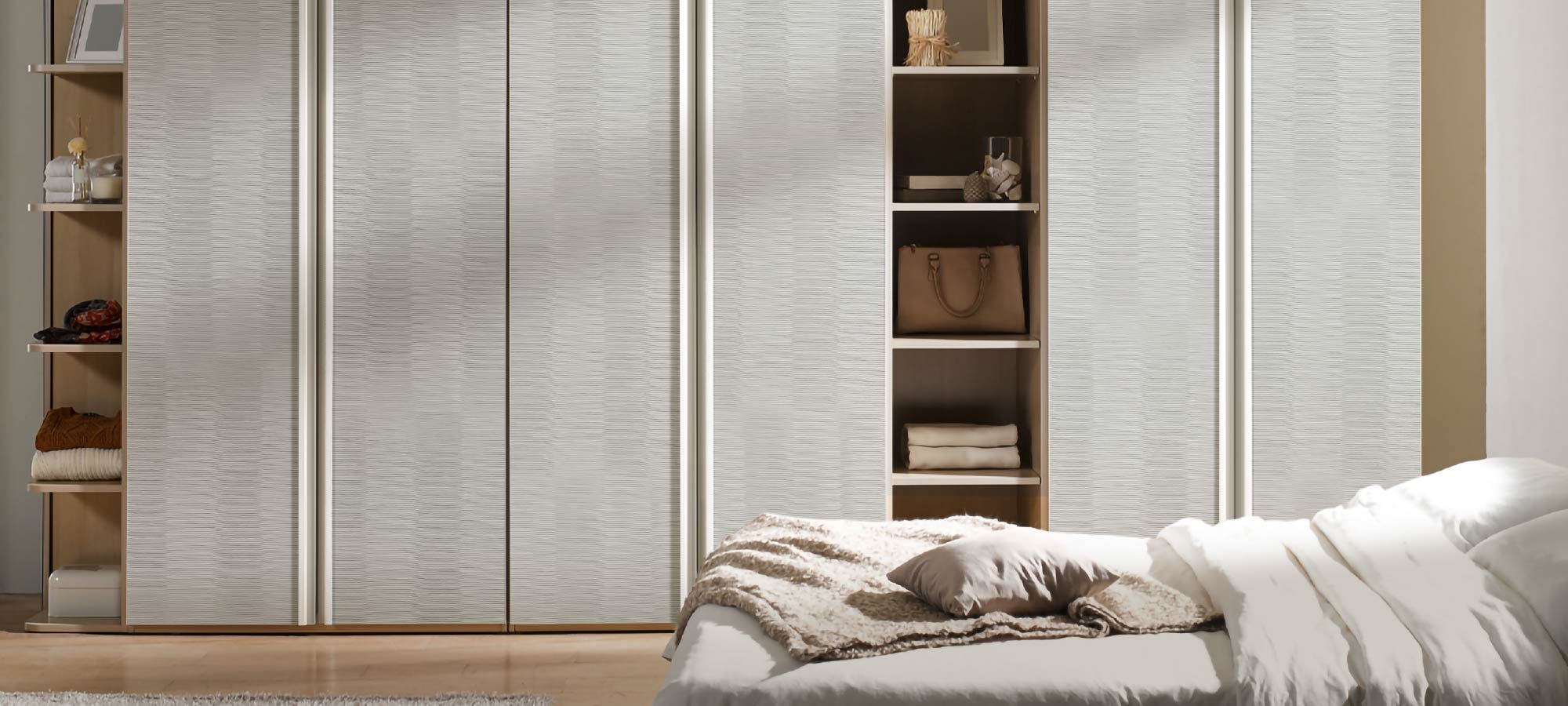 Minimalist bedroom interior with sliding wardrobe doors, soft neutral wall textures, and cozy bedding creating a warm and contemporary atmosphere.