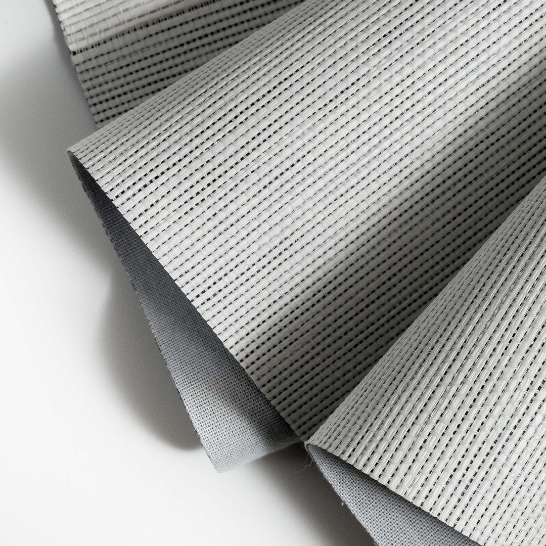 Close-up of a textured vanilla-colored woven fabric with a gray backing, showing fine parallel lines and pleated folds.