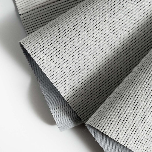 Close-up of a textured vanilla-colored woven fabric with a gray backing, showing fine parallel lines and pleated folds.