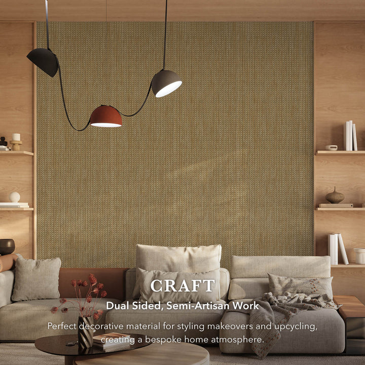 Contemporary living room with a large woven-texture wallpaper feature wall in earthy beige tones, complemented by neutral sofas, wooden shelving, and modern pendant lighting, with text overlay describing the fabric’s dual-sided, semi-artisan craftsmanship.