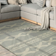 Gray sectional sofa with a patterned rug in a living room setting