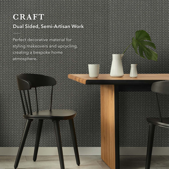 Dining area with wooden table, black chairs, and decorative items against a patterned wall.