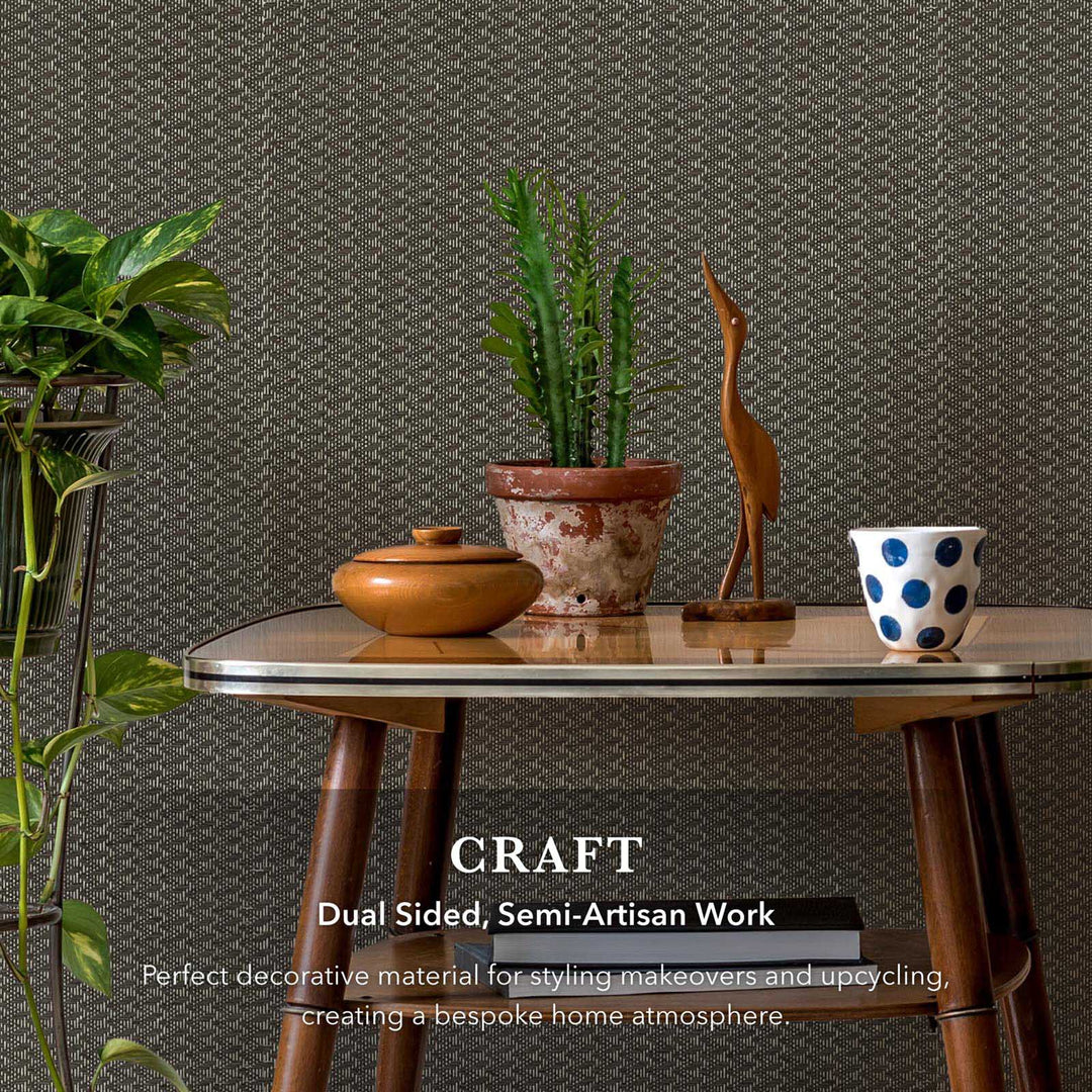 Decorative table with plants, a wooden bird sculpture, and a polka dot bowl against a textured wall.