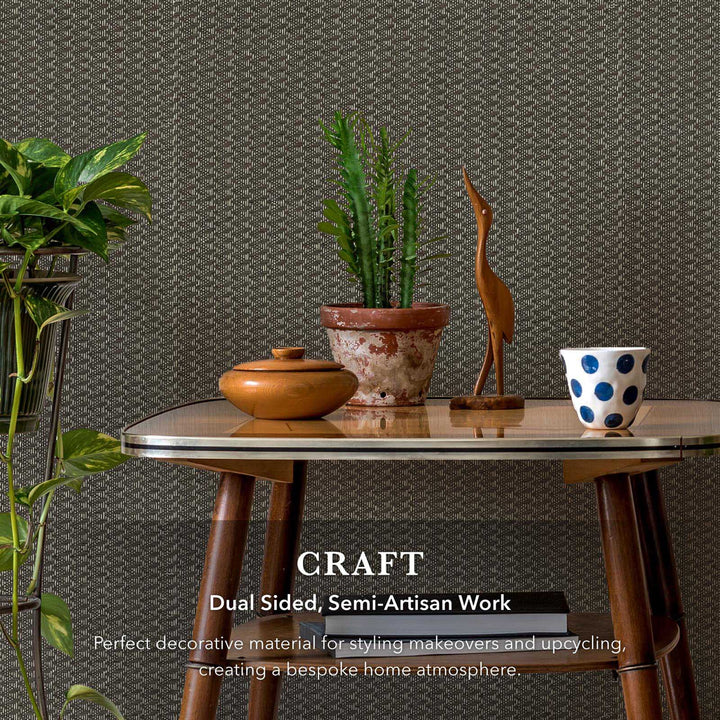 Decorative table with plants, a wooden bird sculpture, and a polka dot bowl against a textured wall.