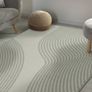 Wavy patterned rug in a room with a gray sofa and wooden stools.