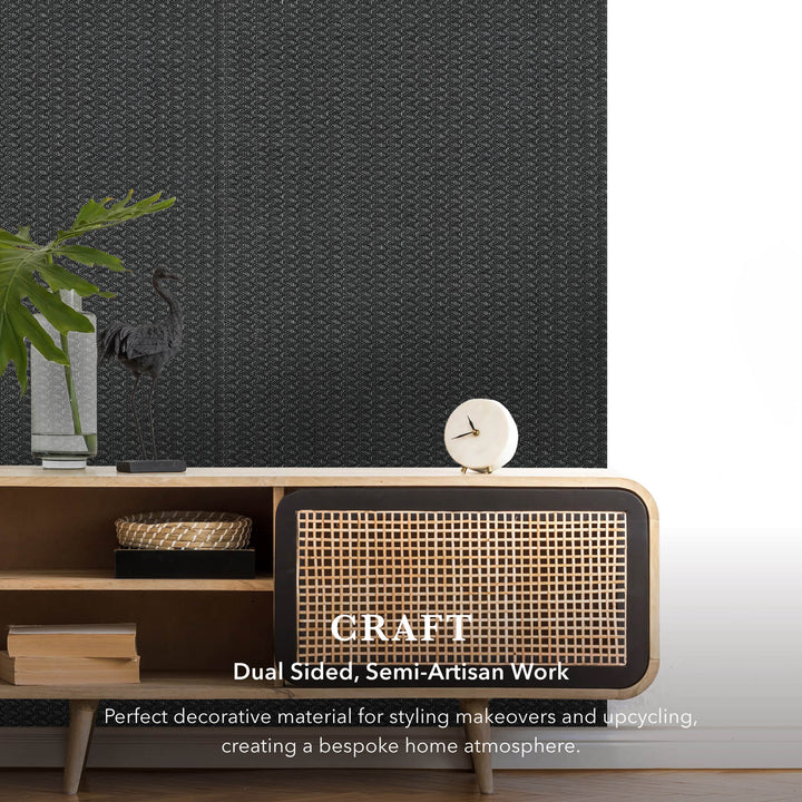 Wooden cabinet with woven design against a textured black wall.