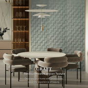 Dining room with a round table and chairs, featuring a textured wall and modern decor.