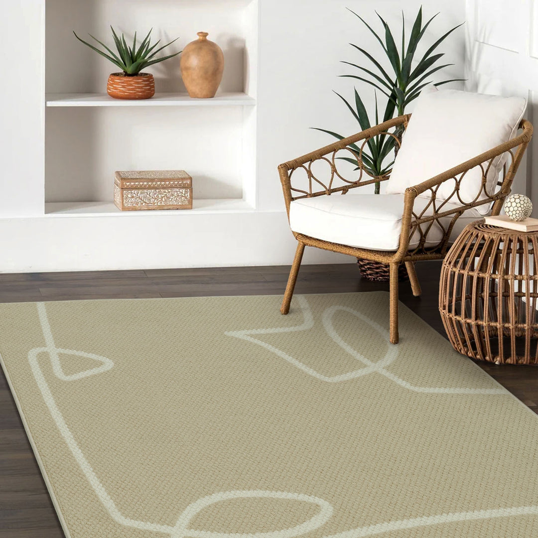 Living room with a beige rug featuring white line art, a wooden chair with a white cushion, and decorative items on a shelf.
