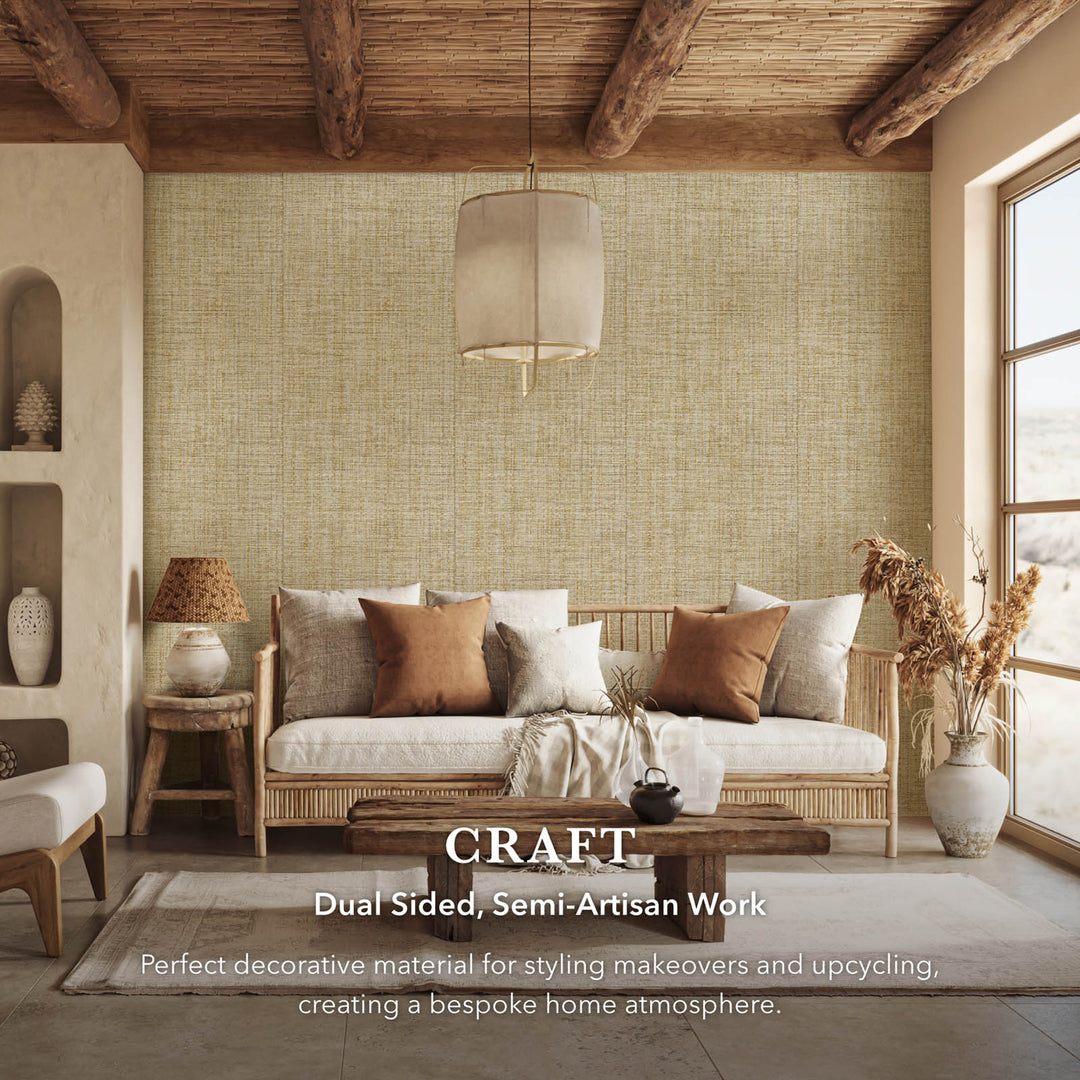 Rustic living room interior with beige textured wallpaper, rattan sofa, earthy toned cushions, wooden coffee table, and text overlay highlighting dual sided semi-artisan decorative fabric.