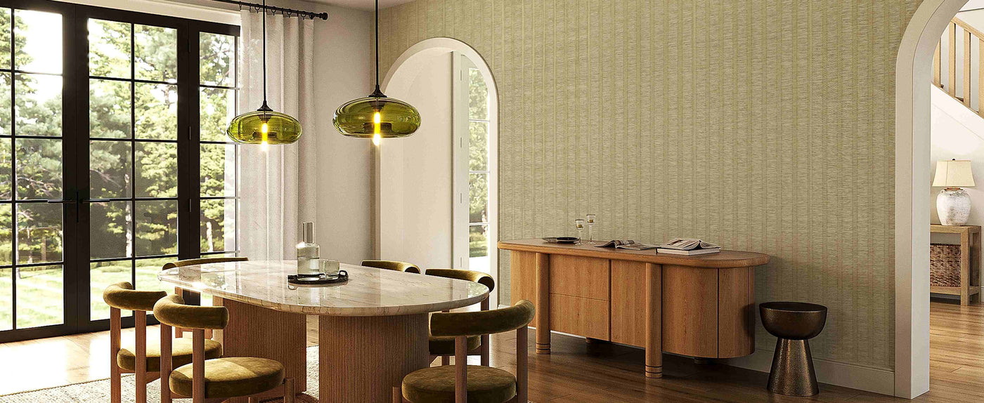 Elegant dining room with oval marble table, green velvet chairs, pendant lights, and light beige textured vertical stripe wallpaper accent wall.