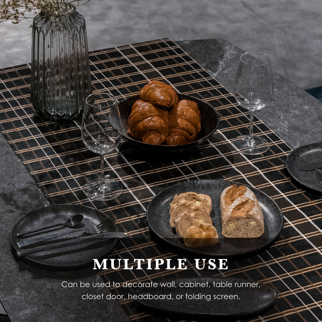 Table setting with bread, croissants, and wine glasses on a textured surface.