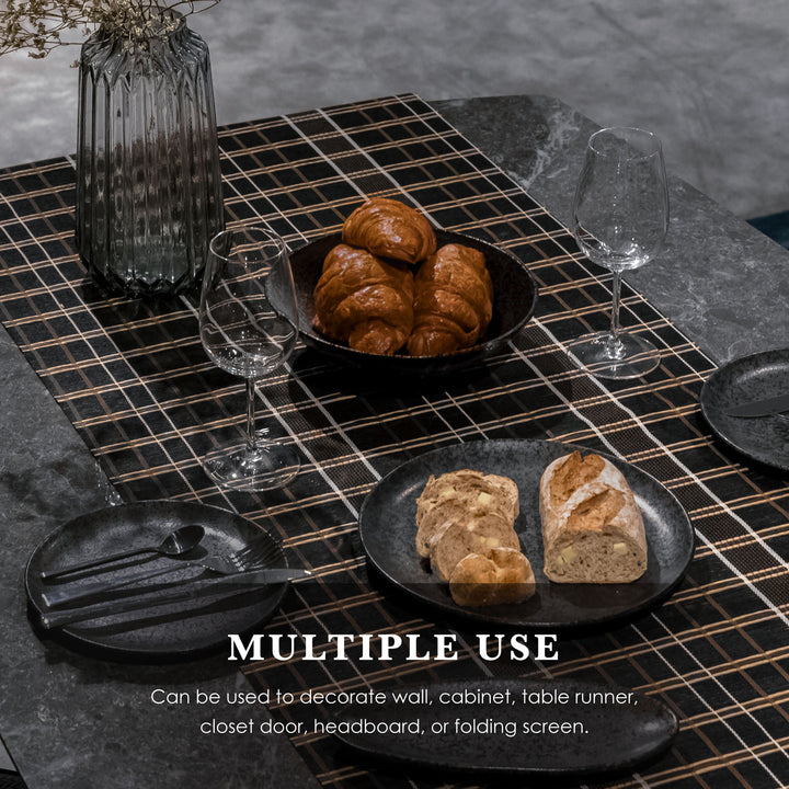 Table setting with bread, croissants, and wine glasses on a textured surface.