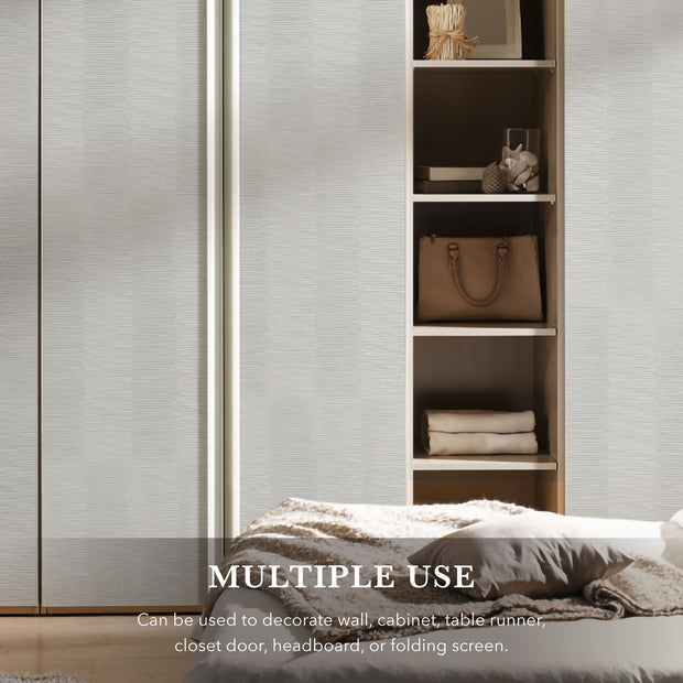 Bedroom setting with a bed and wooden shelf against a textured wall.