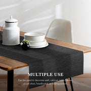 Black table runner on a wooden table with white decor items, text indicating multiple uses.